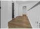 Bright hallway featuring hardwood floors, white trim, and black doors at 3385 Wayland Dr, Ladson, SC 29456