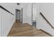 Upstairs hallway with hardwood flooring, white trim, and black doors at 3385 Wayland Dr, Ladson, SC 29456