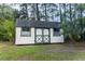 Storage shed with painted white siding and green trim surrounded by pine trees and grass at 3385 Wayland Dr, Ladson, SC 29456