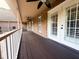 Long covered porch with brick walls, ceiling fans, and a stained wood floor at 3385 Wayland Dr, Ladson, SC 29456