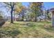 A spacious backyard featuring mature trees, a wooden shed, a basketball court, and a lush green lawn at 3627 Marginal Rd, Mount Pleasant, SC 29466