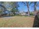 A view of the home's backyard, featuring a concrete basketball court and mature trees at 3627 Marginal Rd, Mount Pleasant, SC 29466