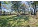A lush backyard featuring trees, grass and a basketball court on a bright sunny day at 3627 Marginal Rd, Mount Pleasant, SC 29466