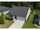 Aerial view of home showcasing driveway, roof, and landscaped front yard in a neighborhood setting at 3806 Sourwood Ct, Ladson, SC 29456