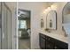 En suite bath with double sinks, dark cabinets, and shower visible through the door at 3806 Sourwood Ct, Ladson, SC 29456
