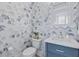 Charming powder room featuring blue vanity, marble countertop, decorative mirror, and whimsical wallpaper at 3870 Fifle St, Mount Pleasant, SC 29466
