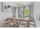 Bright dining room with modern chandelier, table with seating for eight, and three bright windows at 3870 Fifle St, Mount Pleasant, SC 29466