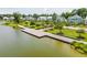 A long wooden dock extends into a peaceful lake, adjacent to a well-manicured lawn and charming homes at 3870 Fifle St, Mount Pleasant, SC 29466
