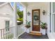 Charming entryway with a wood door, decorative wreath, and potted flowers for a welcoming ambiance at 3870 Fifle St, Mount Pleasant, SC 29466