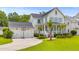 Inviting two-story home with a detached garage, a basketball hoop, and a lush green lawn at 3870 Fifle St, Mount Pleasant, SC 29466