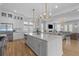 Bright, open kitchen with large island, stainless steel appliances, and flowing view of living room at 3870 Fifle St, Mount Pleasant, SC 29466
