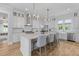 Bright, open kitchen with a large island, white cabinets, stainless steel appliances, and barstool seating at 3870 Fifle St, Mount Pleasant, SC 29466