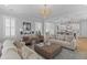 Bright living room featuring hardwood floors, light-colored sofas, and stylish decor flowing into the kitchen at 3870 Fifle St, Mount Pleasant, SC 29466