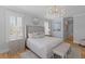 This neutral bedroom offers a chandelier, accent mirror and an upholstered bench for added design at 3870 Fifle St, Mount Pleasant, SC 29466