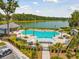 A resort-style pool is surrounded by lush landscaping and overlooks a serene lake on a sunny day at 3870 Fifle St, Mount Pleasant, SC 29466