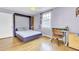 This bedroom offers a murphy bed, built-in shelving, natural light and hardwood floors at 4756 Churchill Rd, North Charleston, SC 29405