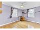 Bright bedroom features hardwood floors, a ceiling fan, and two windows for ample natural light at 4756 Churchill Rd, North Charleston, SC 29405