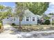 Charming light blue two-story home with landscaped yard, mature trees, and detached garage at 4756 Churchill Rd, North Charleston, SC 29405