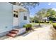 Charming home featuring a light blue exterior, a white front door, and a brick step entrance at 4756 Churchill Rd, North Charleston, SC 29405