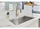Close up of kitchen sink, quartz countertops, stainless appliances and white backsplash at 4756 Churchill Rd, North Charleston, SC 29405