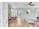 Bright living room features hardwood floors, modern ceiling fan, and dining table next to a decorative built-in at 4756 Churchill Rd, North Charleston, SC 29405