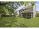 Large, well-maintained backyard with lush green grass, a wood fence, and a screened porch at 4949 Serene Ln, Hollywood, SC 29449