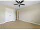 A bedroom has a ceiling fan, closet, door to another room, and wood-look floors at 4949 Serene Ln, Hollywood, SC 29449