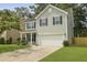 Inviting two-story home featuring green siding, a two-car garage, and a well-maintained front yard at 4949 Serene Ln, Hollywood, SC 29449