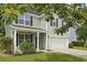 Charming two-story home featuring light green siding, a front porch, and a two-car garage at 4949 Serene Ln, Hollywood, SC 29449