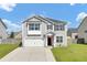 Charming two-story home with gray siding, front lawn, and attached garage at 613 Ravens Wood Rd, Summerville, SC 29486