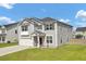 Two-story home featuring gray siding, a well-manicured lawn, and an attached garage at 613 Ravens Wood Rd, Summerville, SC 29486
