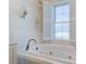 Bathroom with soaking tub, plants, and bright lighting from the window at 656 Coleman Blvd # 402, Mount Pleasant, SC 29464