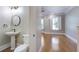 Bathroom with pedestal sink and toilet, adjacent to bedroom featuring natural light and hardwood floors at 656 Coleman Blvd # 402, Mount Pleasant, SC 29464