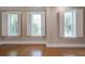 Light-filled bedroom with hardwood floors and three windows featuring plantation shutters at 656 Coleman Blvd # 402, Mount Pleasant, SC 29464