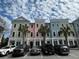 Charming townhomes boast vibrant, pastel exteriors complemented by lush palm trees and convenient parking at 656 Coleman Blvd # 402, Mount Pleasant, SC 29464