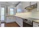Well-lit kitchen featuring white cabinets, stainless steel appliances, granite countertops, and a door leading to the exterior at 656 Coleman Blvd # 402, Mount Pleasant, SC 29464