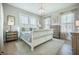 This bedroom features a beautiful chandelier, natural light, and a soothing color palette at 7935 Flagship Ln, Johns Island, SC 29455