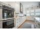 Well-lit kitchen features stainless steel appliances, white cabinets, and hardwood flooring at 7935 Flagship Ln, Johns Island, SC 29455