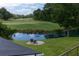 Relaxing backyard view of the golf course, pond with water feature, and a charming seating area at 806 Westos Way, Mount Pleasant, SC 29464