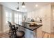 Granite counters and white cabinets accent this kitchen island with bar seating and modern pendant lighting at 806 Westos Way, Mount Pleasant, SC 29464
