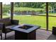 Relaxing screened-in porch with a fire pit, comfortable seating, and a view of the pond and golf course at 806 Westos Way, Mount Pleasant, SC 29464