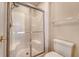 Bathroom featuring glass enclosed shower, tiled walls, and a toilet at 9117 Woodcreek Ct, North Charleston, SC 29406
