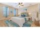Bright bedroom featuring beach decor, a ceiling fan, and windows with blue curtains at 9117 Woodcreek Ct, North Charleston, SC 29406