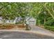 Charming home with a well-manicured front yard, mature trees, and a paved driveway at 9117 Woodcreek Ct, North Charleston, SC 29406