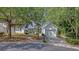 Attractive home with mature trees, a manicured front yard, and a paved driveway at 9117 Woodcreek Ct, North Charleston, SC 29406