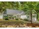 Charming one-story home with an attached garage and beautifully landscaped front yard with a palm tree at 9117 Woodcreek Ct, North Charleston, SC 29406