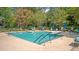 Community pool with lounge chairs, umbrellas, and meticulously landscaped surroundings at 9117 Woodcreek Ct, North Charleston, SC 29406