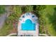 Aerial view of a community pool with lounge seating and landscaping, surrounded by trees at 9117 Woodcreek Ct, North Charleston, SC 29406