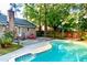 A private backyard oasis with an in-ground pool, patio, mature landscaping and red chairs at 109 Garbon Dr, Summerville, SC 29485