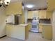 Cozy kitchen featuring warm yellow cabinetry, mosaic tile backsplash, and a breakfast bar at 109 Garbon Dr, Summerville, SC 29485